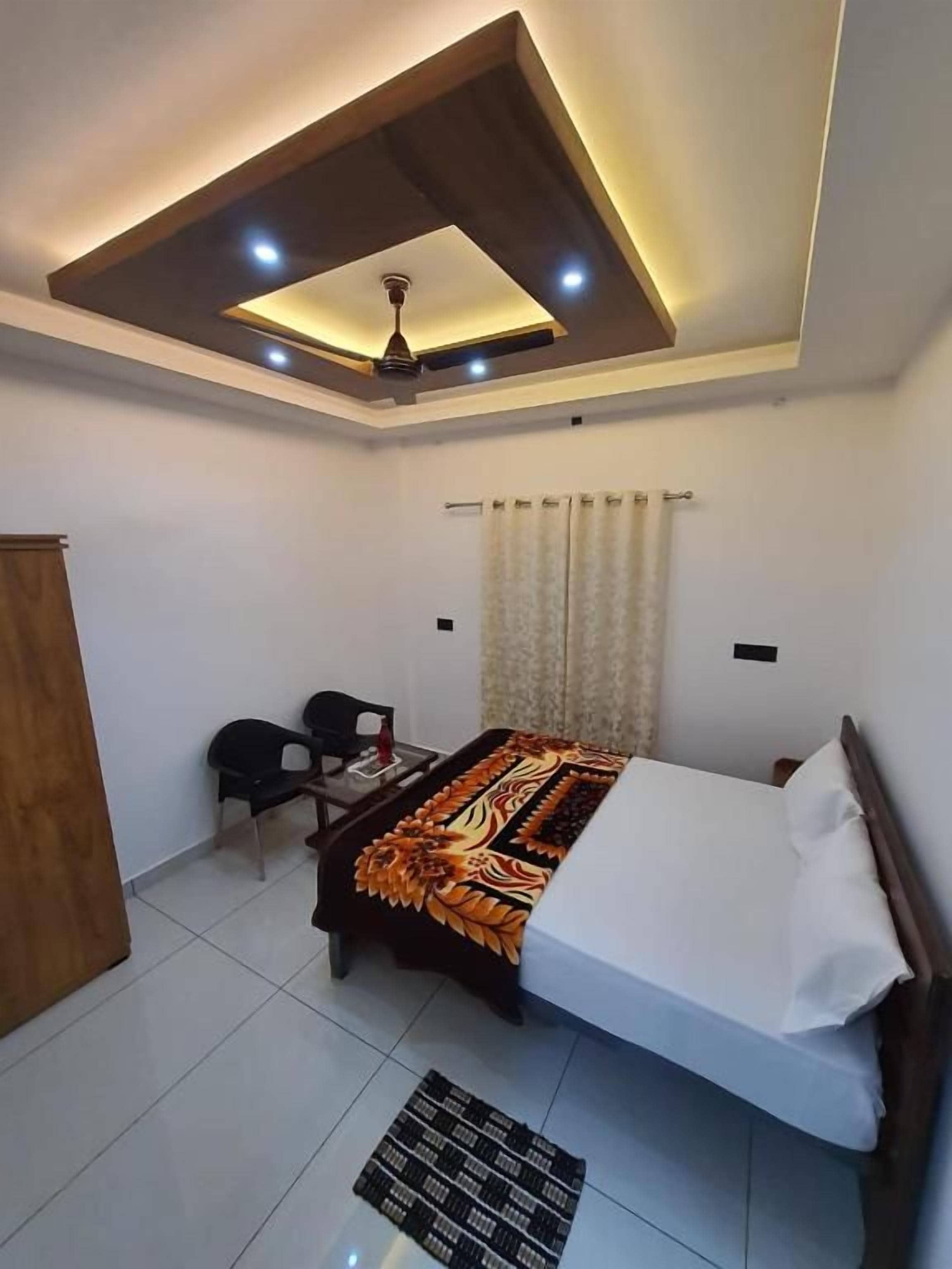 Un dormitorio con cama, escritorio, silla y ventilador de techo.