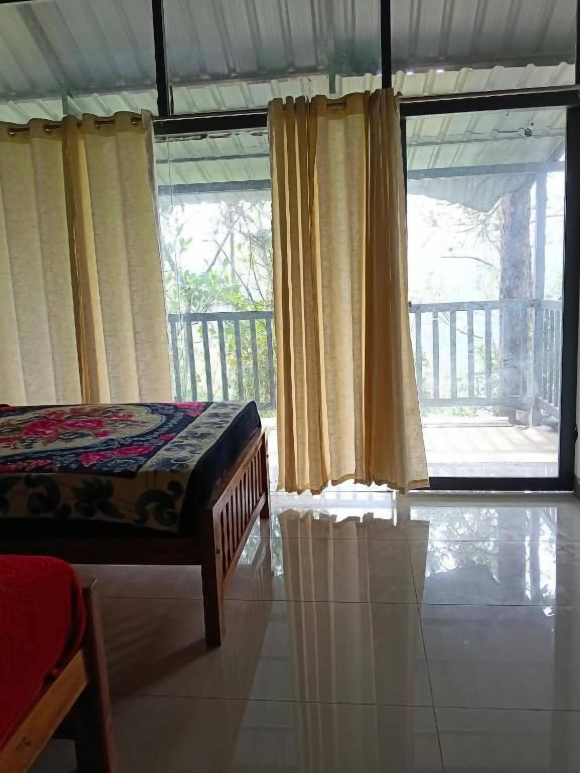 Una habitación con cama, ventana con cortinas y vistas al exterior.