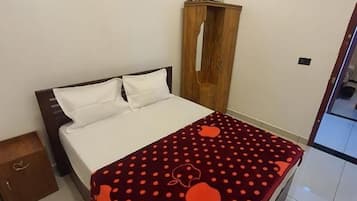 Un dormitorio con una cama, un armario de madera y un espejo en la pared.