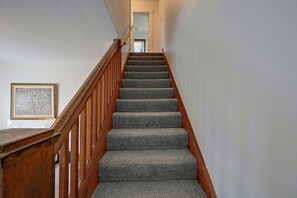 A staircase with wooden handrails and carpeted steps leading to an upper floor. - Walkable Canton Duplex Near Fairgrounds & Dtwn! (Canton)
