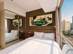A hotel room with a large bed, a mirror, and artwork on the wall. - Kisah By SanLiving - 3BR - Kasablanka (Jakarta)
