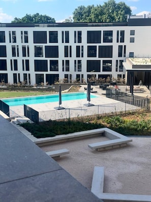 A modern building with a swimming pool, outdoor seating, and a landscaped area. - Rosebank Retreat, Business or Leisure (Johannesburg)