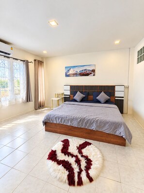 A modern bedroom with a bed, a painting, and a rug. - Charming 2-bedroom House Rental in Muang Pattaya (Pattaya)