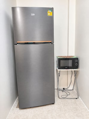 A stainless steel beko refrigerator with a Samsung microwave on a small cart beside it. - Charming 2-bedroom House Rental in Muang Pattaya (Pattaya)
