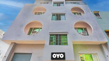 Un edificio con un diseño arquitectónico único, con aberturas circulares y un llamativo letrero 'OYO'.