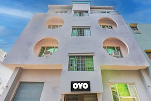 Un edificio con un diseño arquitectónico único, con aberturas circulares y un llamativo letrero 'OYO'.
