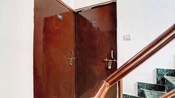 A wooden door with a number plate, a metal handle, and a key lock.