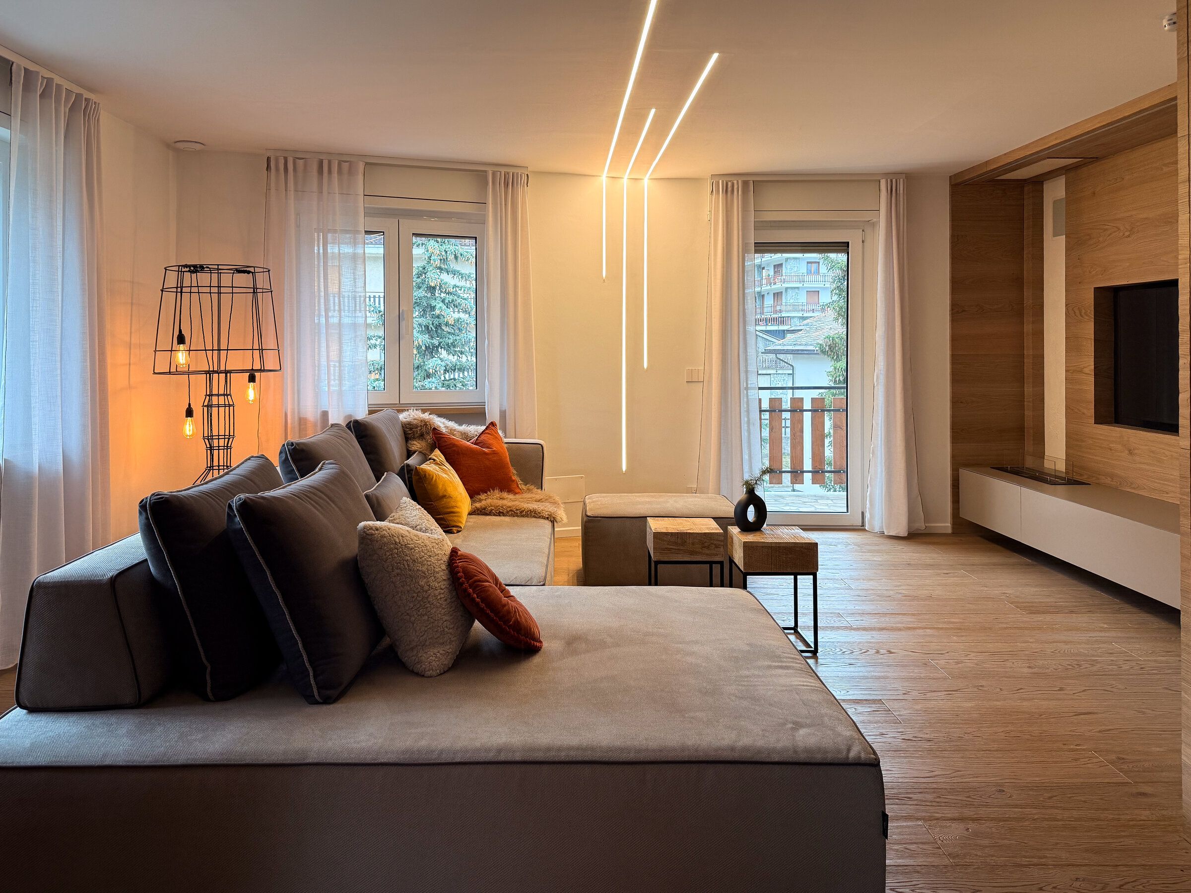 Un salon moderne avec un canapé, une table basse et un téléviseur fixé au mur.