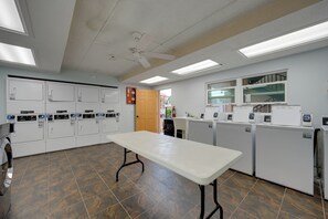 Eine Wäscherei mit mehreren Waschmaschinen, einem Trockenbereich und einem Tisch.