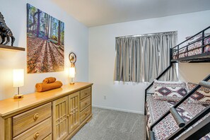 A room with a bunk bed, a wooden dresser, a painting of a forest, and a window with curtains. - Private Pool Oasis | Fiber Wi-Fi | Near Stadium (Peoria)