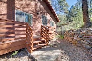 A wooden cabin with a porch and stone wall. - Cozy Prescott Cabin, Surrounded By Ponderosa Pines (Prescott)