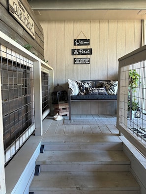 A wooden porch with a bench and a sign that reads 'Welcome to Our Porch.'