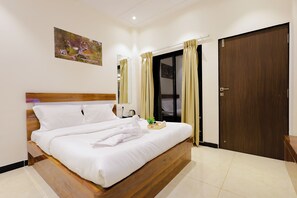 A hotel room with a bed, a nightstand, a mirror, a door, and a painting on the wall. - Coastal Cliff by ILIF Hotels (Murud)