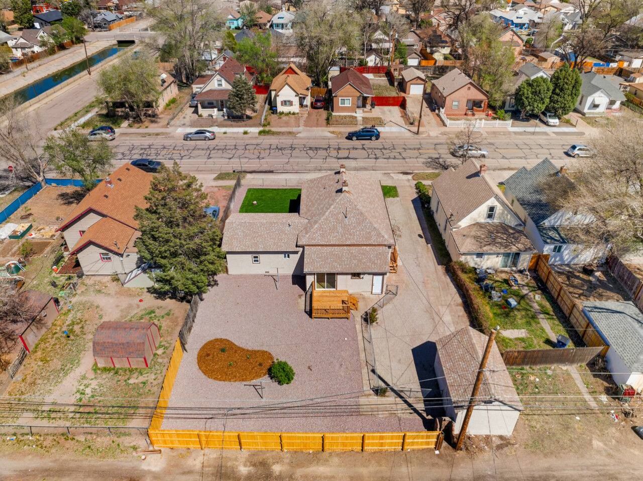 Vista aérea de una zona residencial con casas, un río y cielo despejado.