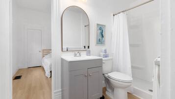 Un baño con ducha, inodoro y lavabo.