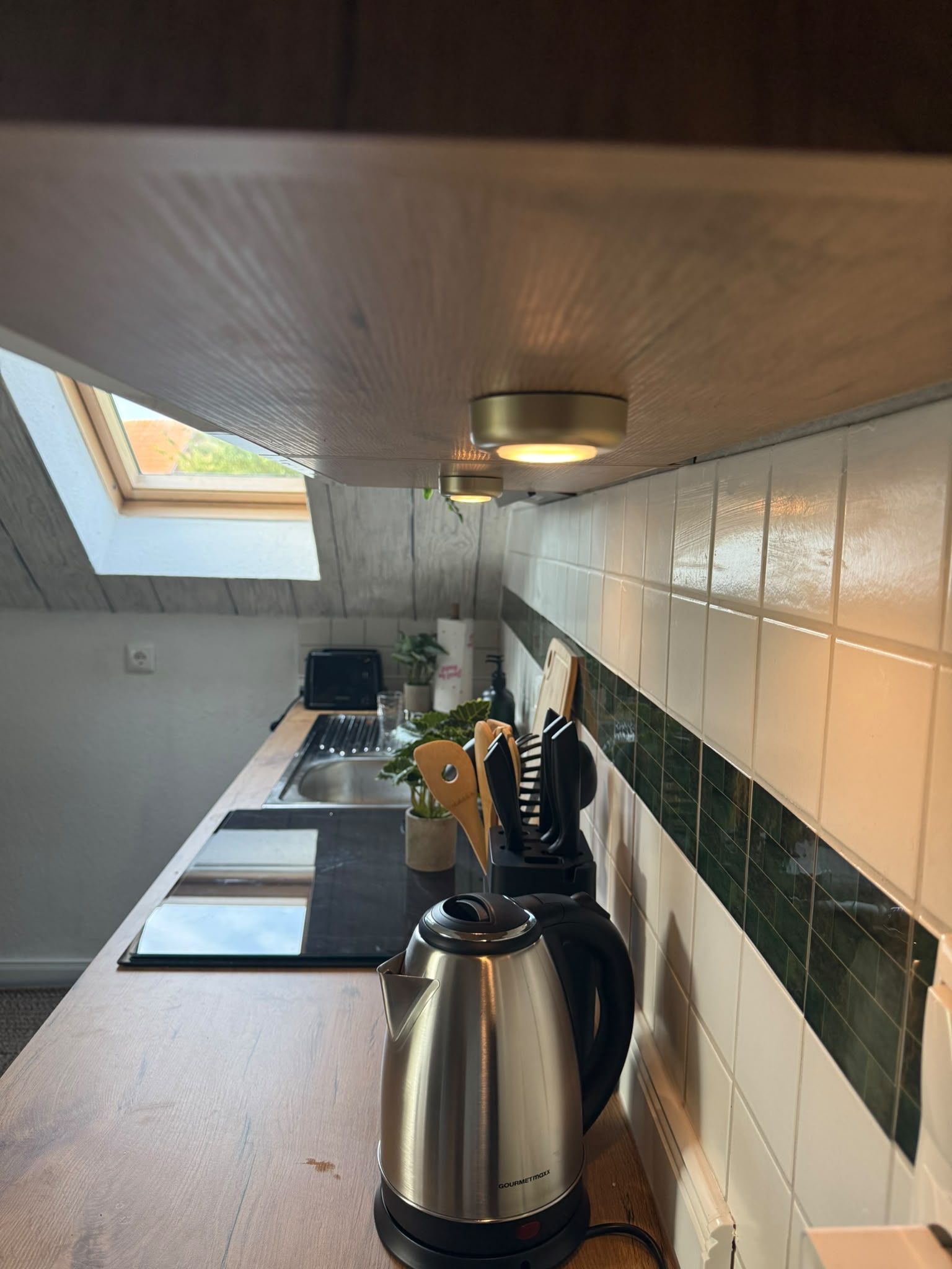 Eine Küche mit Oberlicht, Wasserkocher und Toaster auf der Arbeitsfläche.