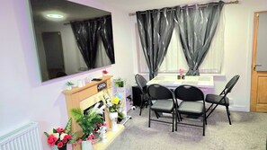 A room with a dining table, chairs, a mirror, and a radiator. - A Cozy 2 bedroom apartment close to NEC & Airport (West Midlands)