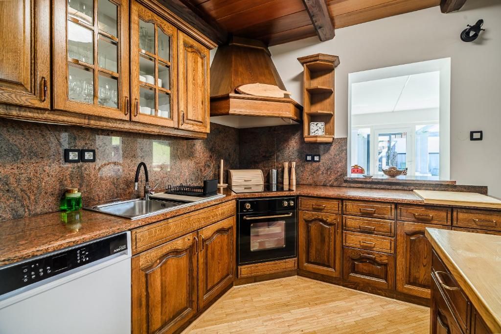 Una cocina con armarios de madera, horno empotrado y una ventana.
