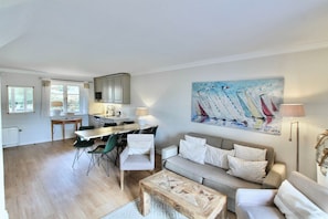 A modern living room with a sofa, coffee table, and dining area with chairs. - Fabian Vacation Rental - 3-room vacation rental in Kampen for 5 people with a terrace, (Kampen (Sylt))