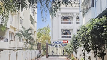 A gated entrance to a building with a sign for 'OYO Rooms'.