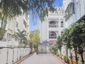 A gated entrance to a building with a sign for 'OYO Rooms'.