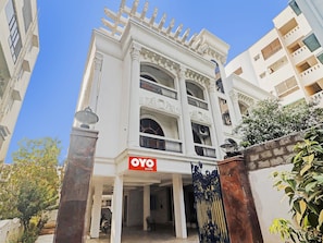 A multi-story building with a sign indicating 'OYO ROOMS' at the entrance.