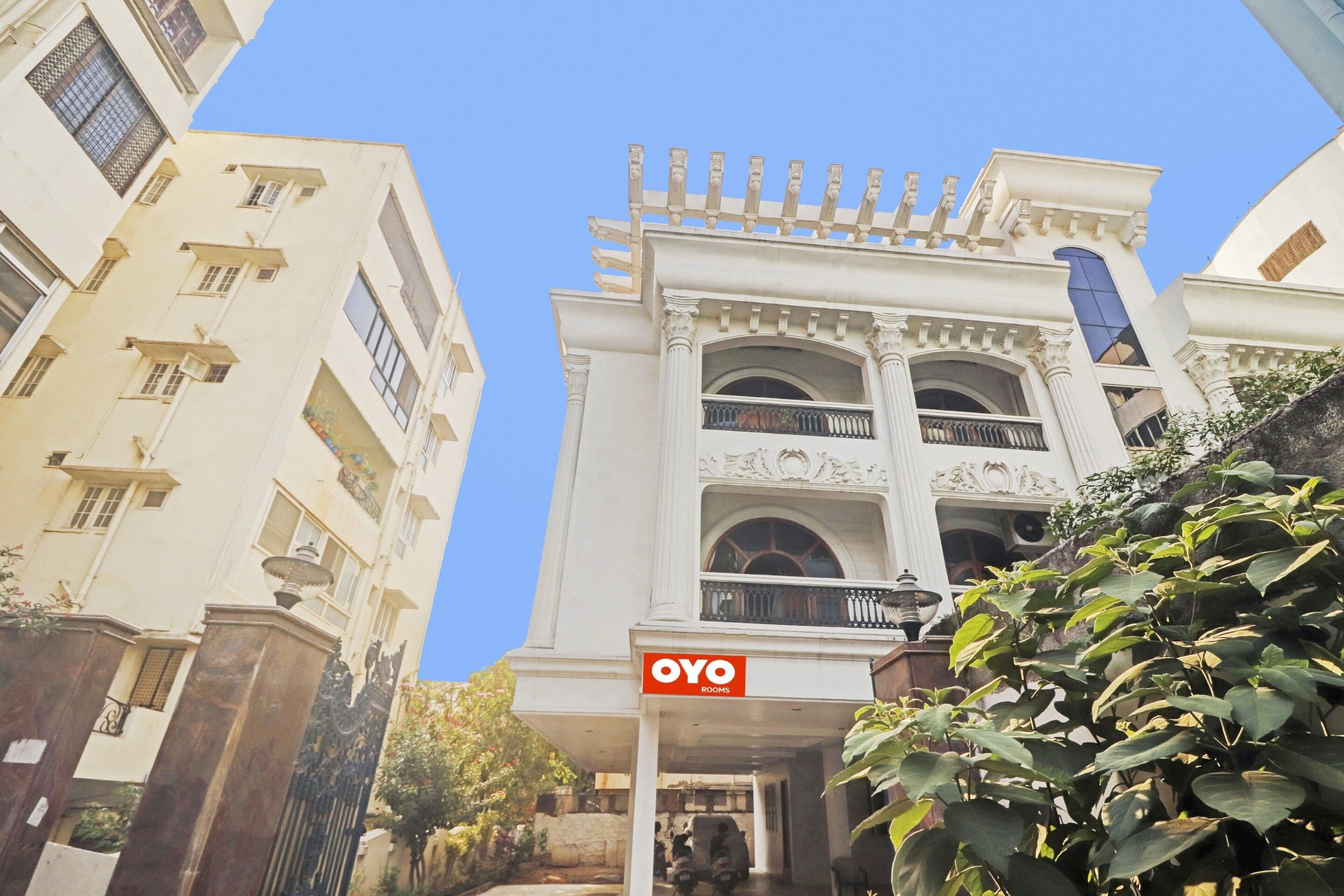 A hotel entrance with a sign for 'OYO rooms' and a covered entrance area.