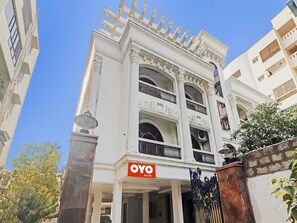 A building with a sign reading 'OYO ROOMS' at the entrance, featuring classical architectural elements like columns and decorative moldings.