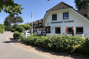 A white building with the sign 'FERIENRESIDENZ COLUMBUS' indicating a hotel. - Holiday apartment with 1 bedroom (Hohwacht)