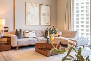 En moderne stue med en sofa, et sofabord og en lampe. To billeder hænger på væggen.