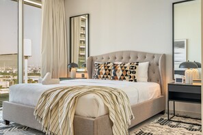Et hotelværelse med en stor seng, udsigt over byen og et moderne design.