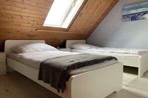 A bedroom with two beds, a skylight, and a painting on the wall. - Holiday home in Langholz with barbecue (Langholz)