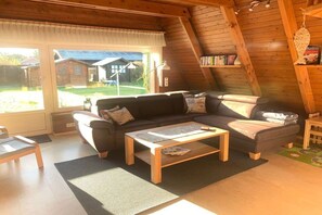 A cozy living room with a sofa, coffee table, and a view of the outside. - Holiday home in Damp with swimming pool (Damp)