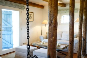 A room with a white sofa, a lamp, and a wooden beam structure. - Holiday home in Gelting with swimming pool (Gelting)