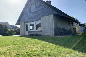A residential house with a sloped roof, a brick exterior, and a well-maintained lawn. - Holiday home in Langholz with swimming pool (Langholz)