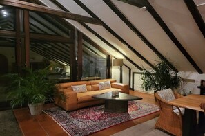 Uma sala de estar aconchegante com sofá, mesa de centro e plantas em vasos.