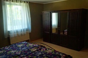 A bedroom with a bed, a wardrobe, and a window with curtains. - Holiday apartment with 2 bedrooms (Panker\/ Gadendorf)