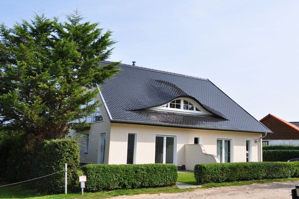 A single-story house with a sloped roof, a small porch, and a well-maintained lawn.