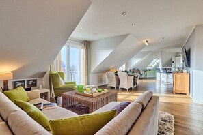 Ein modernes Loft mit hohen Decken, einem Essbereich und einer Küche.