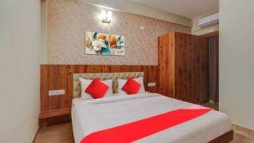 Un dormitorio con una cama, cabecera, una obra de arte en la pared y un armario.