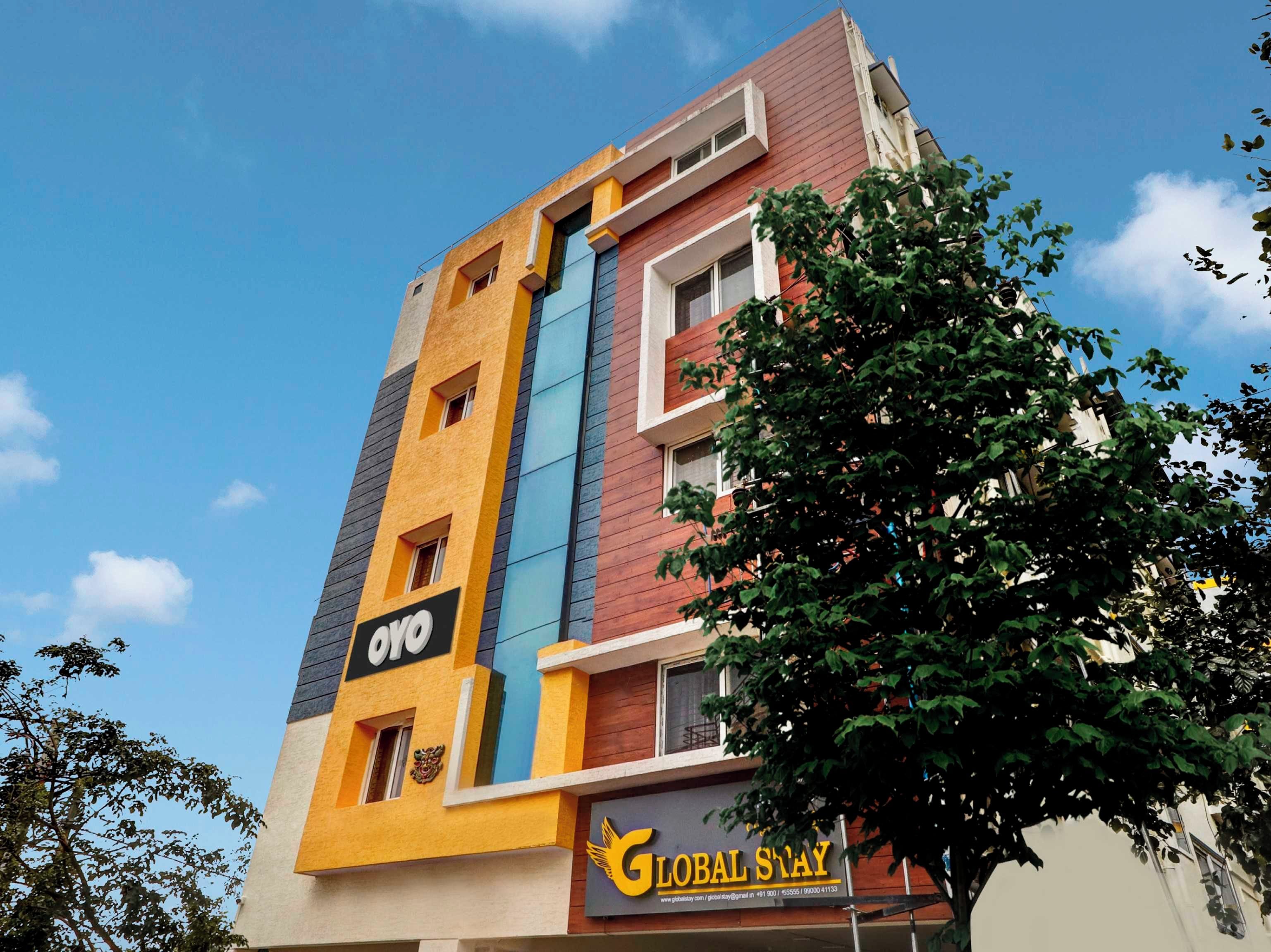 Un edificio de varios pisos con un letrero llamativo que dice 'GLOBAL STAY'.