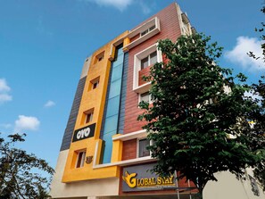 Un edifici de diversos pisos amb un cartell ben visible de 'GLOBAL STAY'.