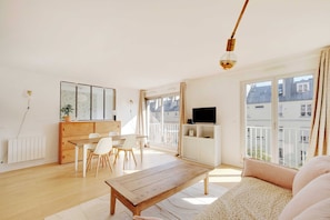 A spacious living room with a wooden coffee table, a sofa, and a TV. - Spacious Parisian Apartment - 2br/4p - Republique (Paris)