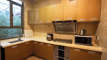 Una cocina moderna con electrodomésticos de acero inoxidable, armarios de madera y un ventanal que proporciona luz natural.