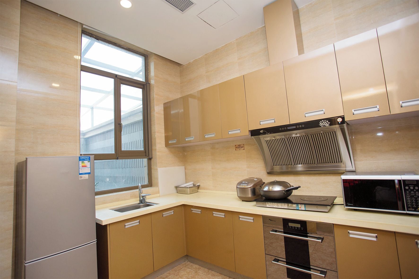 Una cocina equipada con refrigerador, estufa, microondas y ventana.