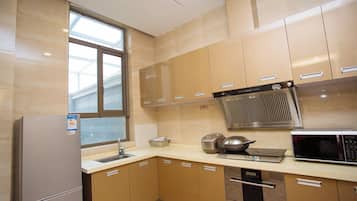 Una cocina equipada con refrigerador, estufa, microondas y ventana.