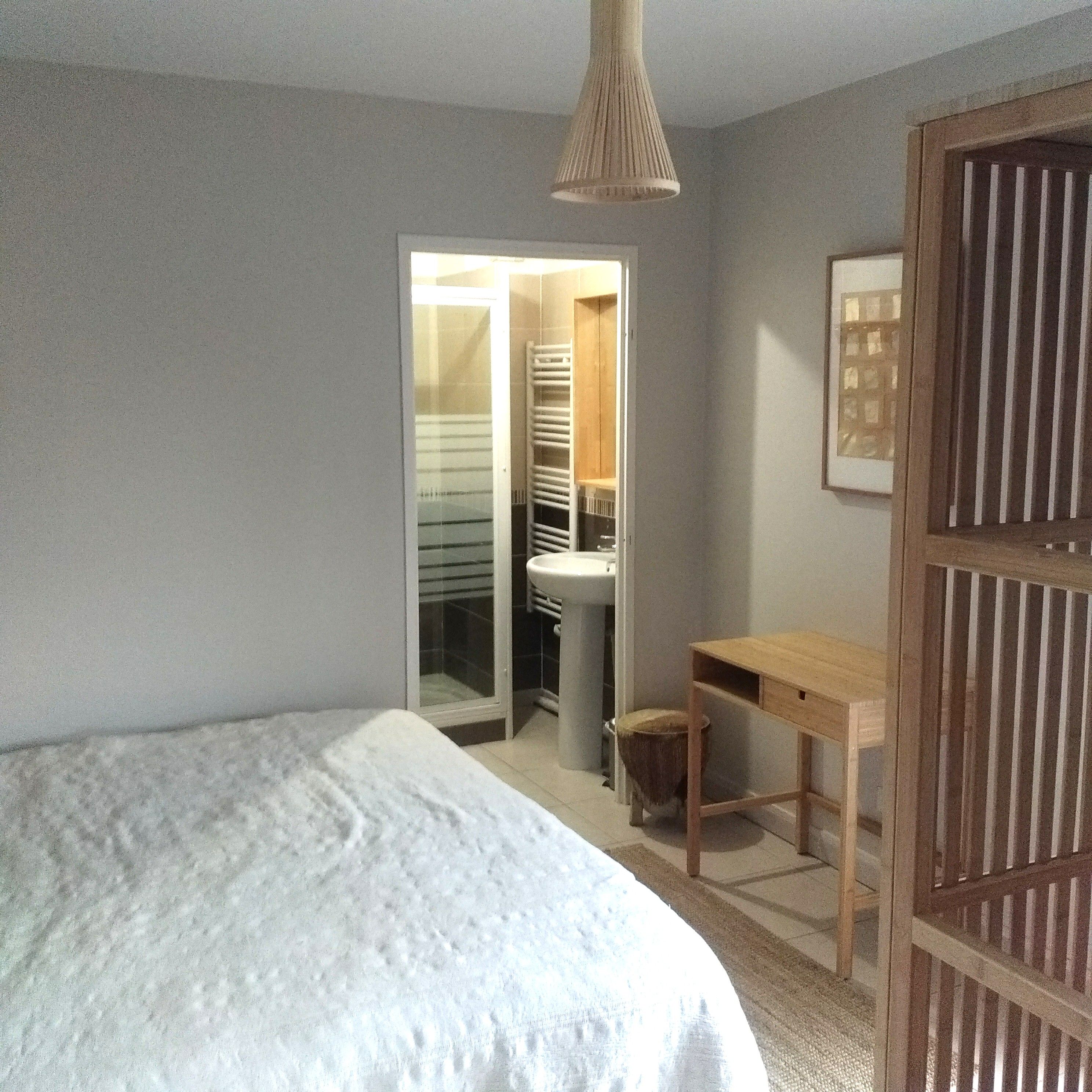 Un dormitorio con cama, escritorio y armario.