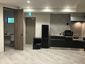 Una cocina moderna con microondas integrado, pileta y cafetera.