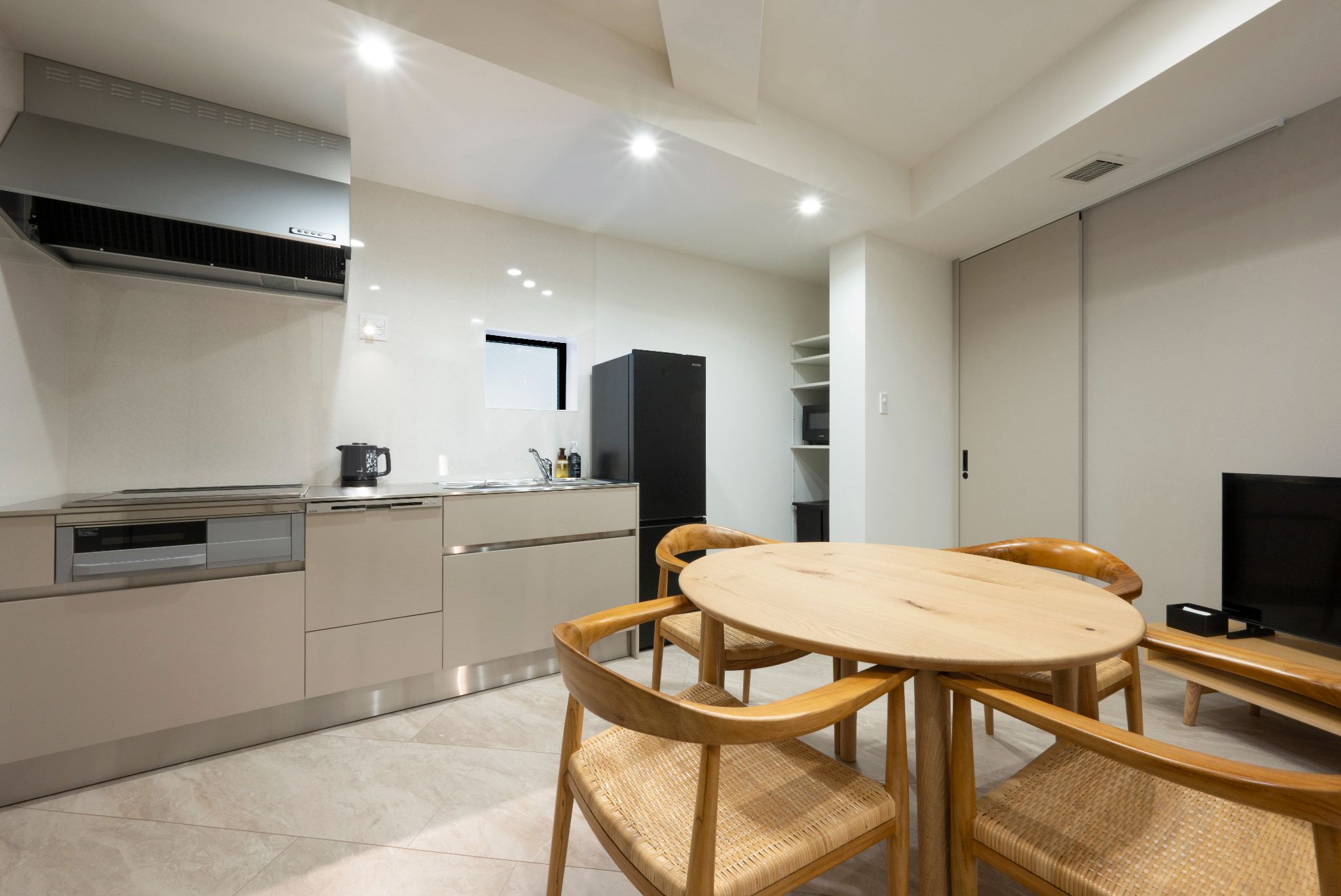 A modern kitchen with a dining area, including a round table and chairs.