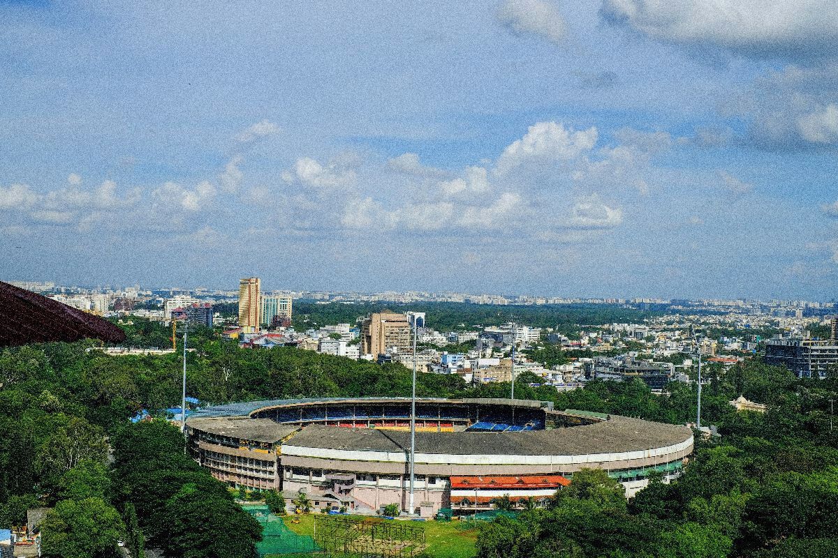 Ein Stadion, umgeben von Grünflächen und Stadtgebäuden.